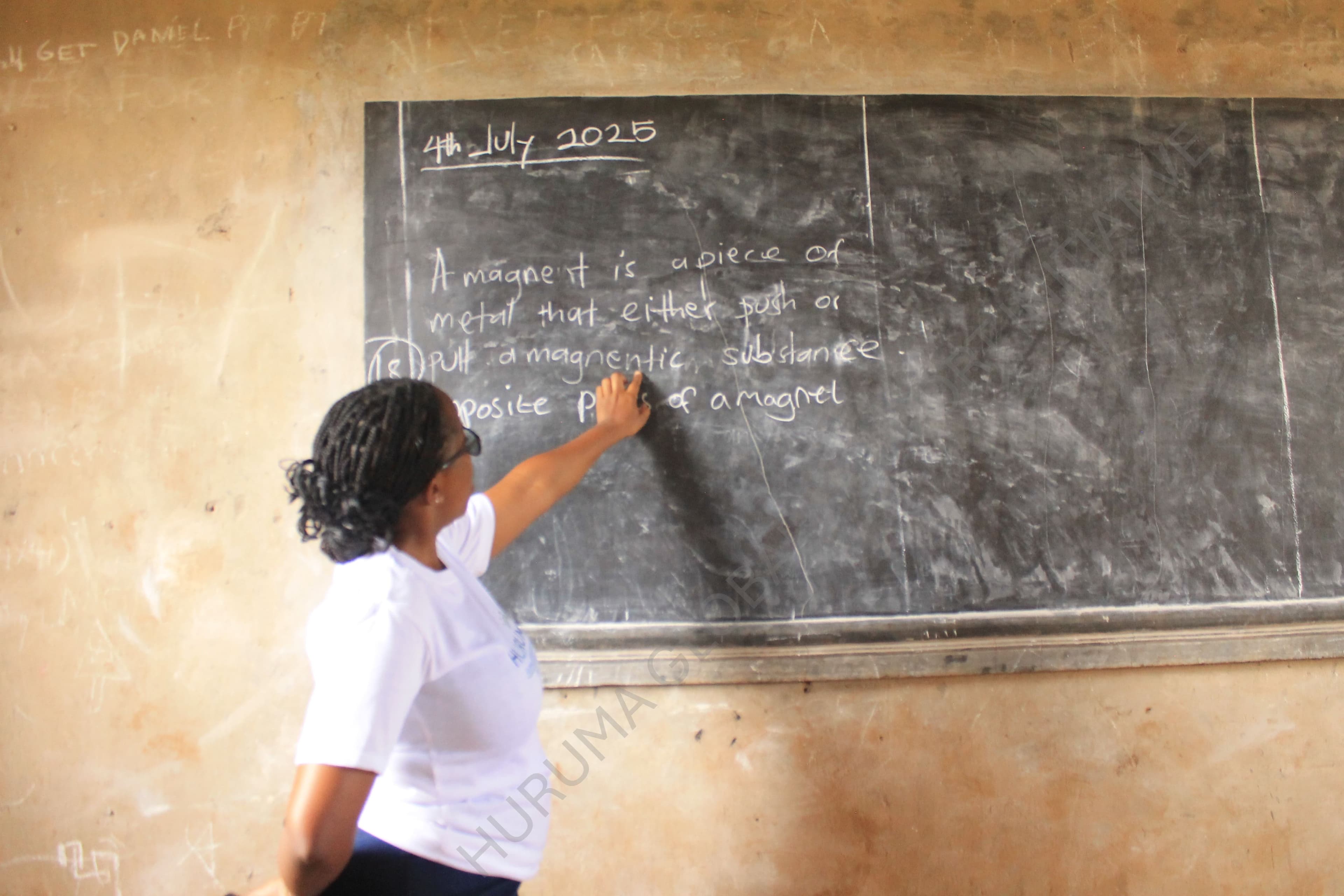 A teacher leading a lesson at the chalkboard